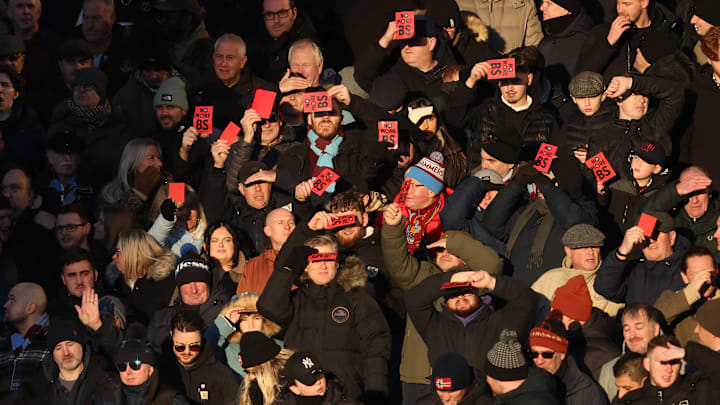 West Ham fans show their disappointment by holding up red cards to express they want owners David Sullivan and his top exectuive Karen Brady out after an embarrassing rock bottom lose to Wolverhampton. 