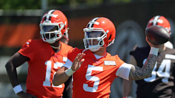 Cleveland Browns quarterback Dillon Gabriel (5) throws as quarterback Shedeur Sanders (12) looks on during rookie minicamp May 9, 2025, in Berea.