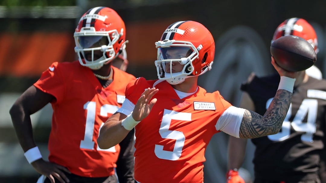 Cleveland Browns quarterback Dillon Gabriel (5) throws as quarterback Shedeur Sanders (12) looks on during rookie minicamp May 9, 2025, in Berea.