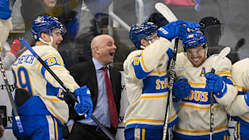 Feb 8, 2025; St. Louis, Missouri, USA;  St. Louis Blues left wing Pavel Buchnevich (89) head coach Jim Montgomery center Dylan Holloway (81) and center Robert Thomas (18) react after center Radek Faksa (not pictured) scored the game winning goal in the 10th round of shootouts against the Chicago Blackhawks at Enterprise Center. Mandatory Credit: Jeff Curry-Imagn Images