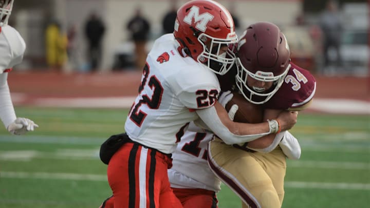 Killingly's Soren Rief looks for some more yardage against Masuk defender Kyle Beckett in last year's Class MM semifinal at Killingly High School. Killingly hosts Masuk on Friday, Sept. 8 at 6:30 p.m.
