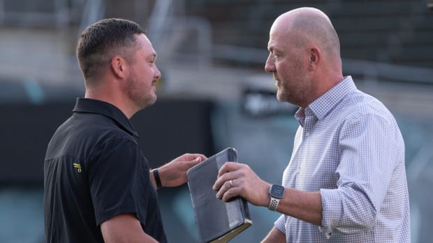 Dan Lanning, left, and Josh Bidwell embrace during a vigil at Autzen Stadium for former football player Khyree Jackson