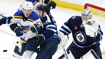 Apr 21, 2025; Winnipeg, Manitoba, CAN; St. Louis Blues right wing Zack Bolduc (76), Winnipeg Jets defenseman Josh Morrissey (44) and Winnipeg Jets goaltender Connor Hellebuyck (37) eye an incoming puck in the third period in game two of the first round of the 2025 Stanley Cup Playoffs at Canada Life Centre. Mandatory Credit: James Carey Lauder-Imagn Images