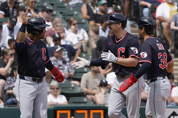 Kyle Manzardo (C) is greeted by third baseman José Ramírez (L) and outfielder Steven Kwan (38).