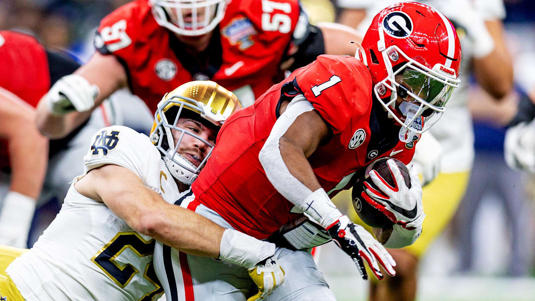 Jan 2, 2025; New Orleans, LA, USA; Georgia Bulldogs defensive back Ellis Robinson IV (1) is tackled by Notre Dame Fighting Irish linebacker Jack Kiser (24) during the second quarter at Caesars Superdome. Mandatory Credit: Stephen Lew-Imagn Images
