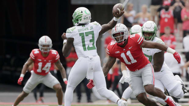 Oregon Ducks quarterback Anthony Brown (13) is pressured by Ohio State Buckeyes defensive end Tyreke Smith (11)