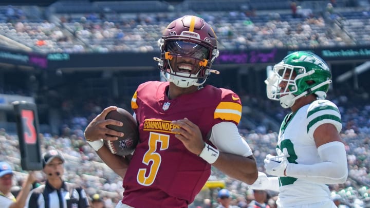 Aug 10, 2024; East Rutherford, New Jersey, USA; Washington Commanders quarterback Jayden Daniels (5) rushes for a touchdown during the first quarter against the New York Jets at MetLife Stadium. Mandatory Credit: Lucas Boland-USA TODAY Sports