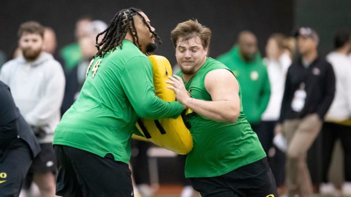 Oregon offensive linemen Steven Jones, left, and Jackson Powers-Johnson run drills during Oregon Pro Day Tuesday, March 12, 2024 at the Moshofsky Center in Eugene, Ore.