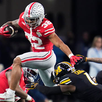 Dec 29, 2023; Arlington, Texas, USA; Ohio State Buckeyes running back TreVeyon Henderson (32) carries the ball against Missouri Tigers defensive back Jaylon Carlies (1) in the first quarter during the Goodyear Cotton Bowl Classic at AT&T Stadium.