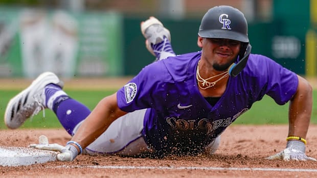 Colorado Rockies player sliding into a base