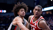 Georgia Bulldogs forward Asa Newell (14) gets to the ball after Oklahoma Sooners forward Jalon Moore (14) took control during their first round game of the SEC Men's Basketball Tournament at Bridgestone Arena in Nashville, Tenn., Wednesday, March 12, 2025.