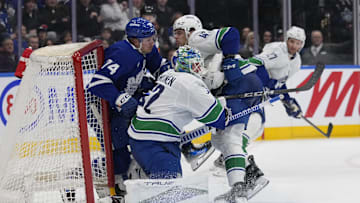 Jan 11, 2025; Toronto, Ontario, CAN; Toronto Maple Leafs forward Bobby McMann (74) gets knocked into the net by Vancouver Canucks defenseman Noah Juulsen (47) as  goaltender Kevin Lankinen (32) tries to get out of the way during the third period at Scotiabank Arena. Mandatory Credit: John E. Sokolowski-Imagn Images