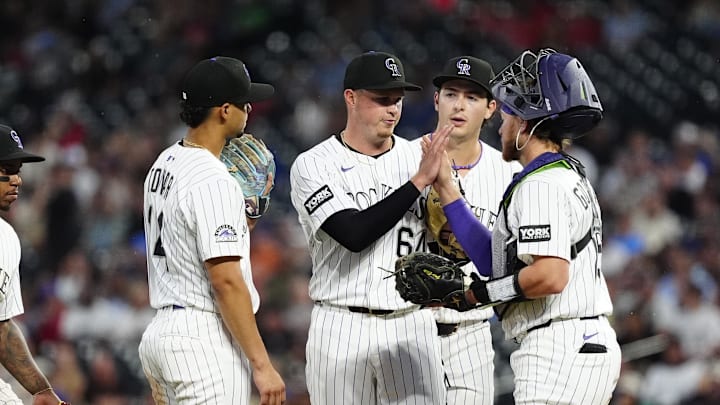 Jul 22, 2025; Denver, Colorado, USA; Colorado Rockies pitcher Bradley Blalock (64) high fives catcher Hunter Goodman (15) in the sixth inning against the St. Louis Cardinals at Coors Field. 