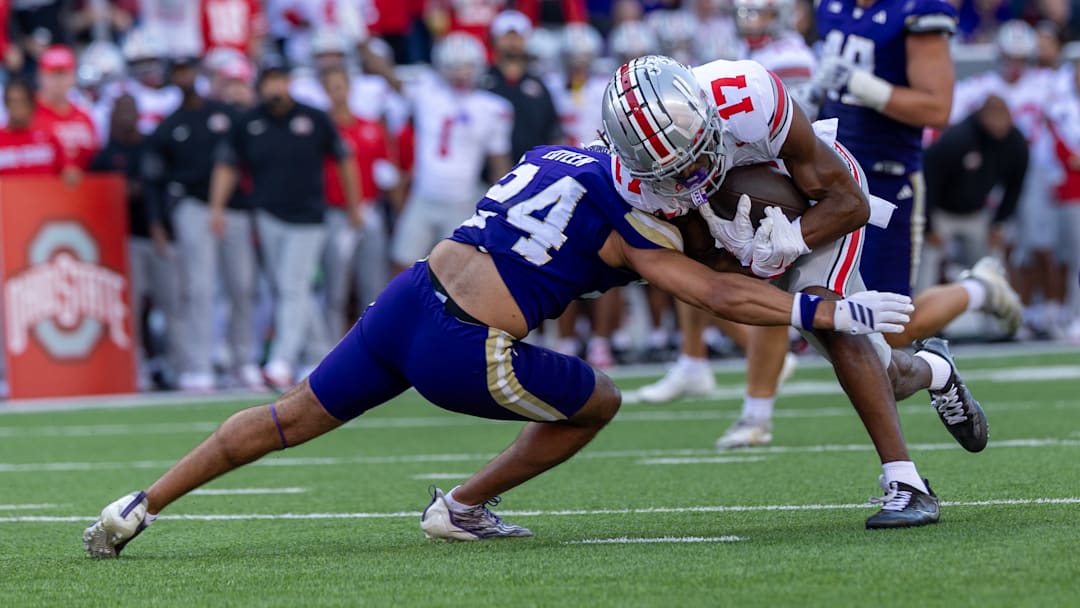 Ohio State wide receiver Carnell Tate (17) picks up an 11-yard first down in the third quarter before being tackled by Huskies safety Makell Esteen. The Buckeyes would score their second touchdown, a one-yard rush, on the next play.