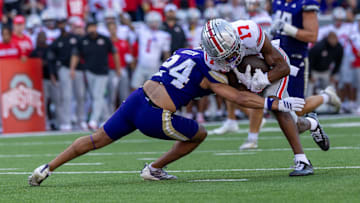 Ohio State wide receiver Carnell Tate (17) picks up an 11-yard first down in the third quarter before being tackled by Huskies safety Makell Esteen. The Buckeyes would score their second touchdown, a one-yard rush, on the next play.