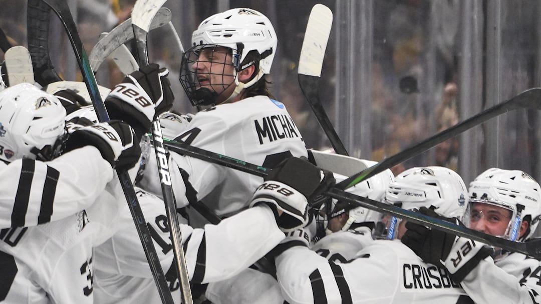Apr 12, 2025; St. Louis, Missouri, UNITED STATES; Western Michigan Broncos forward Owen Michaels (34) leaps in to his bench and celebrates with teammates after scoring an empty net goal against the Boston University Terriers during the third period of the Frozen Four college ice hockey national championship at Enterprise Center. 