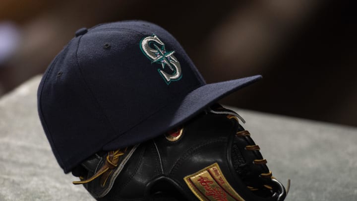 A view of a Seattle Mariners hat and baseball glove during the game between the Texas Rangers and the Mariners at Globe Life Park in Arlington. The Mariners defeated the Rangers 3-1 in 2015.
