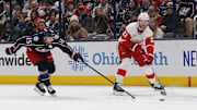 Detroit Red Wings center Michael Rasmussen passes against Columbus Blue Jackets defenseman Dante Fabbro.