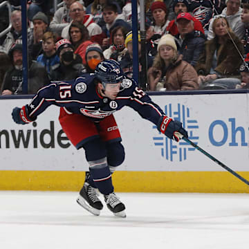 Detroit Red Wings center Michael Rasmussen passes against Columbus Blue Jackets defenseman Dante Fabbro.