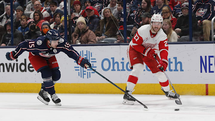 Detroit Red Wings center Michael Rasmussen passes against Columbus Blue Jackets defenseman Dante Fabbro.
