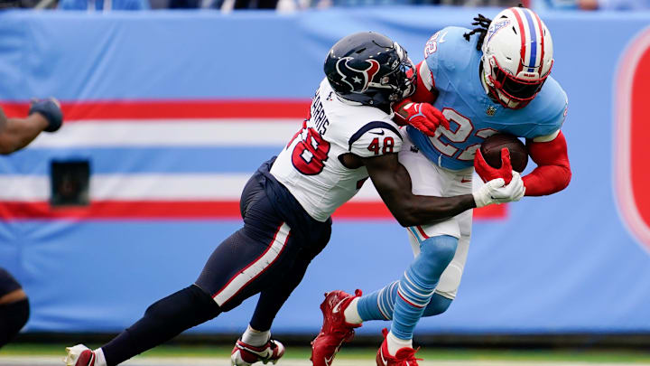 Tennessee Titans running back Derrick Henry (22) is tackled by Houston Texans linebacker Christian Harris (48) during the first quarter at Nissan Stadium in Nashville, Tenn., Sunday, Dec. 17, 2023.