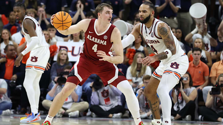 Mar 8, 2025; Auburn, Alabama, USA; Alabama Crimson Tide forward Grant Nelson (4) moves to the basket as Auburn Tigers forward Johni Broome (4) defends during the second half at Neville Arena. Mandatory Credit: John Reed-Imagn Images