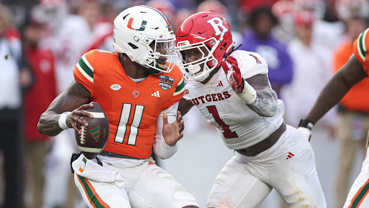 Dec 28, 2023; Bronx, NY, USA; Miami Hurricanes quarterback Jacurri Brown (11) is sacked by Rutgers Scarlet Knights linebacker Mohamed Toure (1) during the first half of the 2023 Pinstripe Bowl at Yankee Stadium. Mandatory Credit: Vincent Carchietta-Imagn Images
