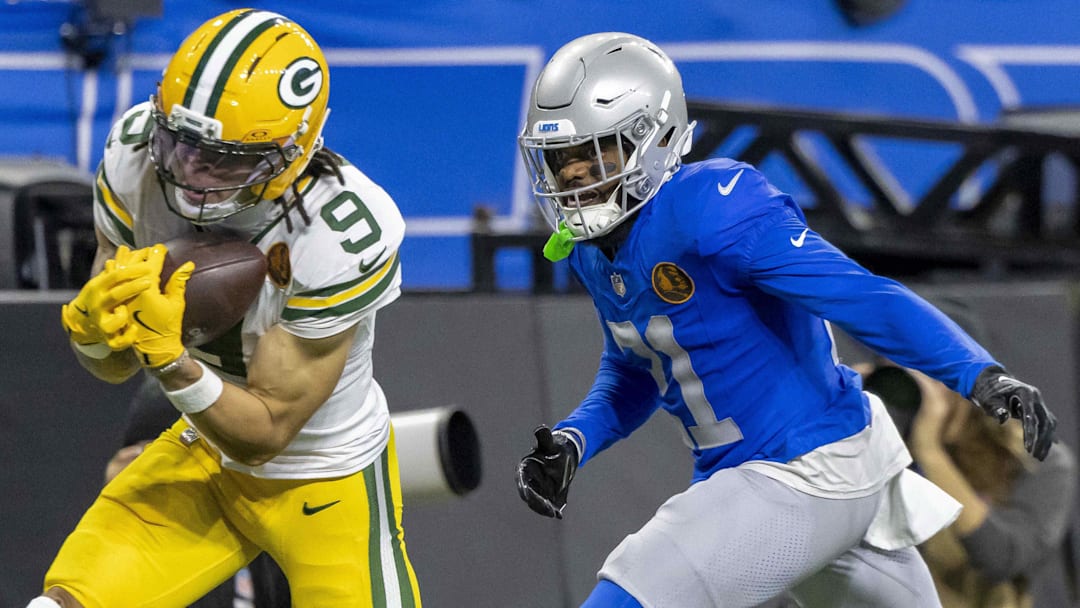 Nov 27, 2025; Detroit, Michigan, USA; Green Bay Packers wide receiver Christian Watson (9) catches a pass against Detroit Lions cornerback Amik Robertson (21) during the third quarter at Ford Field.