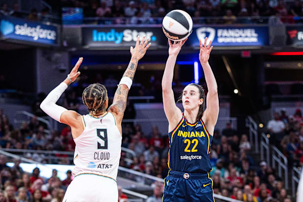 Fever guard Caitlin Clark (22) shoots the ball while Liberty guard Natasha Cloud (9) defends 