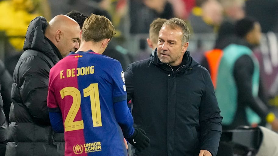 Frenkie de Jong receives instructions from Hansi Flick and Barcelona's coaching staff.