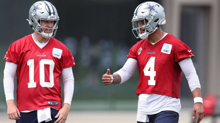 Jun 4, 2024; Frisco, TX, USA; Dallas Cowboys quarterback Cooper Rush (10) talks to quarterback Dak Prescott (4) during practice at the Ford Center at the Star Training Facility in Frisco, Texas. 