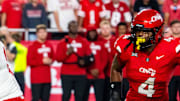 Aug 28, 2025; Kansas City, Missouri, USA; Nebraska Cornhuskers quarterback Dylan Raiola (15) hands the ball off to running back Emmett Johnson (21) against Cincinnati Bearcats defensive lineman Mikah Coleman (4) during the first quarter at GEHA Field at Arrowhead Stadium. Mandatory Credit: Dylan Widger-Imagn Images