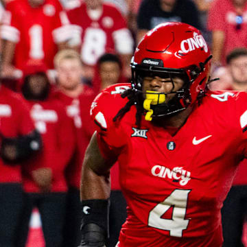 Aug 28, 2025; Kansas City, Missouri, USA; Nebraska Cornhuskers quarterback Dylan Raiola (15) hands the ball off to running back Emmett Johnson (21) against Cincinnati Bearcats defensive lineman Mikah Coleman (4) during the first quarter at GEHA Field at Arrowhead Stadium. Mandatory Credit: Dylan Widger-Imagn Images