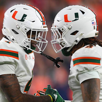 Nov 30, 2024; Syracuse, New York, USA; Miami Hurricanes running back Mark Fletcher Jr. (left) celebrates with running back Damien Martinez (right) after scoring a touchdown against the Syracuse Orange during the first half at the JMA Wireless Dome. Mandatory Credit: Rich Barnes-Imagn Images