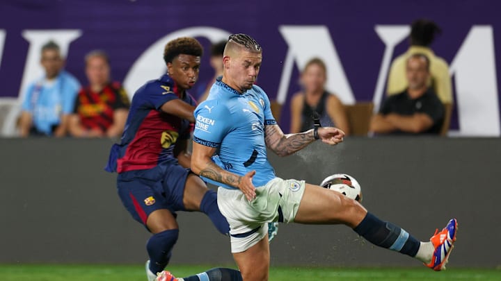 Jul 30, 2024; Orlando, FL, USA; Manchester City midfielder Kalvin Phillips (4) blocks a cross from Barcelona defender Alejandro Balde (3).