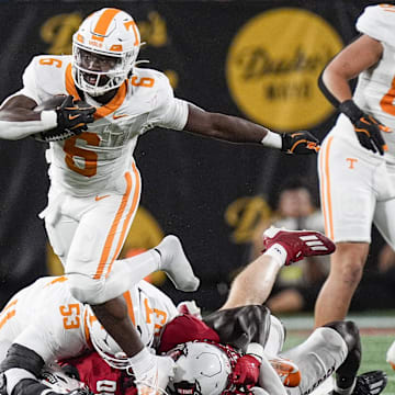 Sep 7, 2024; Charlotte, North Carolina, USA; Tennessee Volunteers running back Dylan Sampson (6) jumps over defenders during the first quarter against the North Carolina State Wolfpack at the Dukes Mayo Classic at Bank of America Stadium. Mandatory Credit: Jim Dedmon-Imagn Images