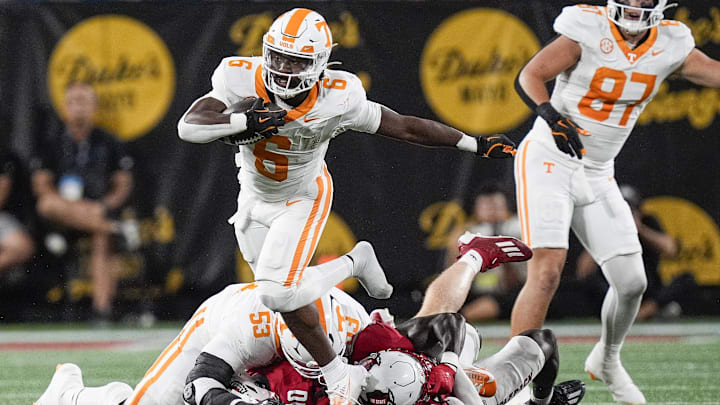 Sep 7, 2024; Charlotte, North Carolina, USA; Tennessee Volunteers running back Dylan Sampson (6) jumps over defenders during the first quarter against the North Carolina State Wolfpack at the Dukes Mayo Classic at Bank of America Stadium. Mandatory Credit: Jim Dedmon-Imagn Images