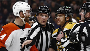 Dec 7, 2024; Boston, Massachusetts, USA; The linesman gets between Philadelphia Flyers center Sean Couturier (14) and Boston Bruins right wing David Pastrnak (88) during the second period at TD Garden.