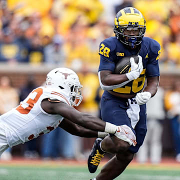 Sep 7, 2024; Ann Arbor, Michigan, USA; Michigan running back Benjamin Hall (28) runs against Texas linebacker David Gbenda (33) during the second half at Michigan Stadium. Mandatory Credit: Junfu Han-USA TODAY Network via Imagn Images