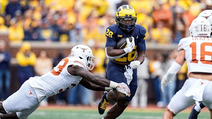 Sep 7, 2024; Ann Arbor, Michigan, USA; Michigan running back Benjamin Hall (28) runs against Texas linebacker David Gbenda (33) during the second half at Michigan Stadium. Mandatory Credit: Junfu Han-USA TODAY Network via Imagn Images