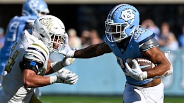 Oct 12, 2024; Chapel Hill, North Carolina, USA;  North Carolina Tar Heels running back Omarion Hampton (28) with the ball as Georgia Tech Yellow Jackets linebacker Kyle Efford (44) defends in the fourth quarter at Kenan Memorial Stadium. Mandatory Credit: Bob Donnan-Imagn Images
