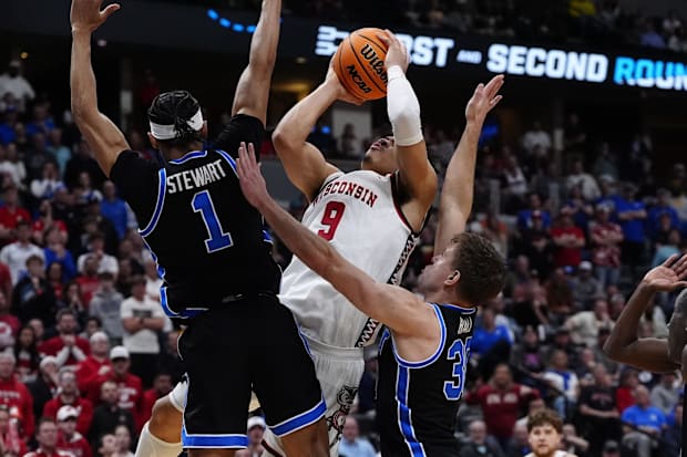 Wisconsin Badgers guard John Tonje (9) shoots the ball over Brigham Young Cougars guard Trey Stewart (1).