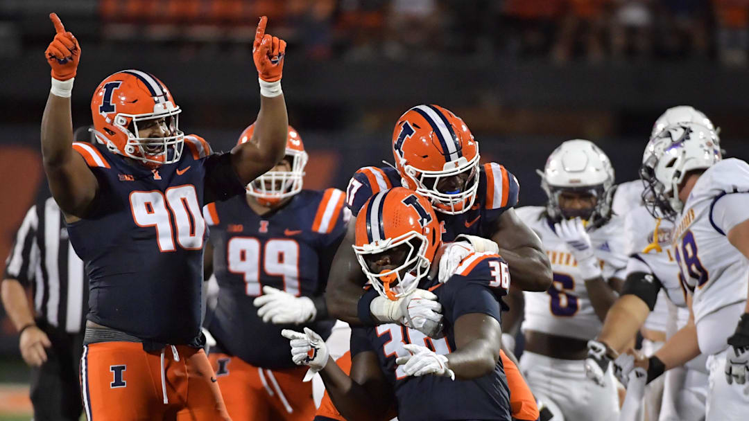 Aug 29, 2025; Champaign, Illinois, USA;  Illinois Fighting Illini linebacker Gabe Jacas (17) jumps on teammate Illinois Fighting Illini defensive lineman Eli Coenen (96) after a sack on Western Illinois Leathernecks quarterback Chris Irvin (5) during the first half at Memorial Stadium. Mandatory Credit: Ron Johnson-Imagn Images