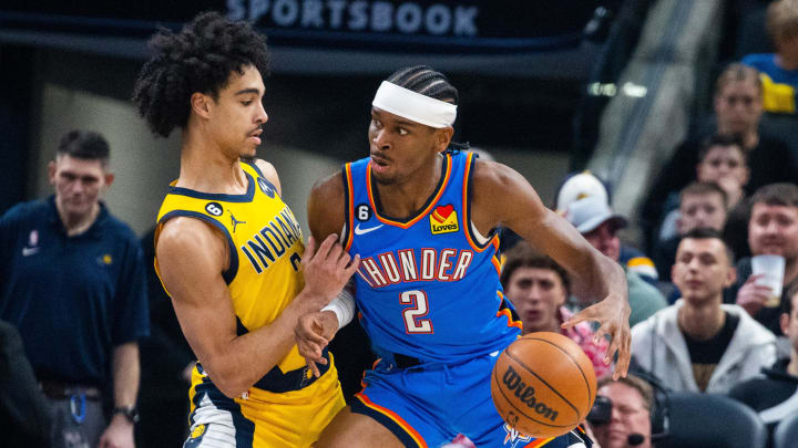 Mar 31, 2023; Indianapolis, Indiana, USA;  Oklahoma City Thunder guard Shai Gilgeous-Alexander (2) dribbles the ball while Indiana Pacers guard Andrew Nembhard (2) defends in the first quarter at Gainbridge Fieldhouse. Mandatory Credit: Trevor Ruszkowski-USA TODAY Sports