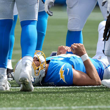 Sep 15, 2024; Charlotte, North Carolina, USA; Los Angeles Chargers quarterback Justin Herbert (10) is slow to get up after a hit against the Carolina Panthers during the second half at Bank of America Stadium. Mandatory Credit: Jim Dedmon-Imagn Images