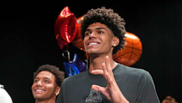 Basketball player NoNo Brown signs with Western New Mexico, left, and Koa Peat, signs with the University of Arizona during National Signing Day at Perry High School in Gilbert, Arizona on April 16, 2025.