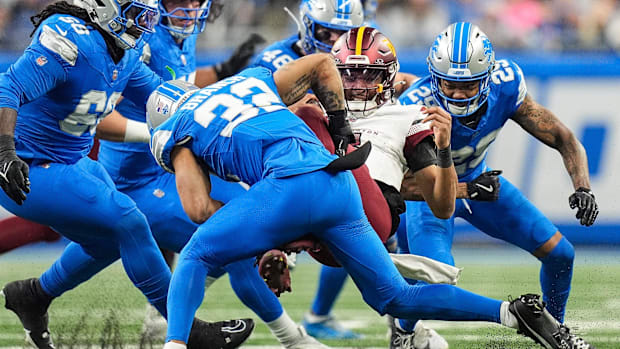 Detroit Lions safety Brian Branch (32) tackles Washington quarterback Jayden Daniels (5) 