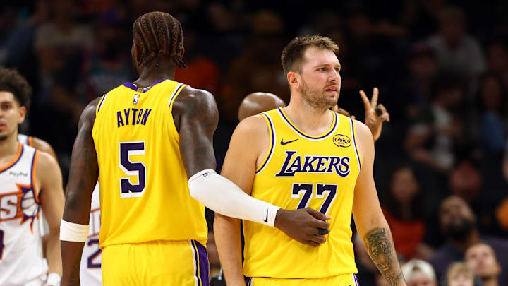 Oct 14, 2025; Phoenix, Arizona, USA: Los Angeles Lakers guard Luka Doncic (77) with center Deandre Ayton (5) against the Phoenix Suns during an NBA preseason game at Mortgage Matchup Center. Mandatory Credit: Mark J. Rebilas-Imagn Images Oct 14, 2025; Phoenix, Arizona, USA: Los Angeles Lakers guard Luka Doncic (77) with center Deandre Ayton (5) against the Phoenix Suns during an NBA preseason game at Mortgage Matchup Center. Mandatory Credit: Mark J. Rebilas-Imagn Images