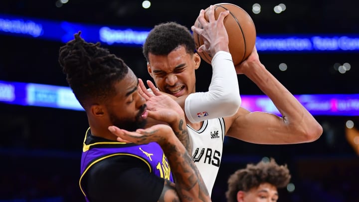 Feb 23, 2024; Los Angeles, California, USA; San Antonio Spurs center Victor Wembanyama (1) gets the rebound against Los Angeles Lakers guard D'Angelo Russell (1) during the first half at Crypto.com Arena.