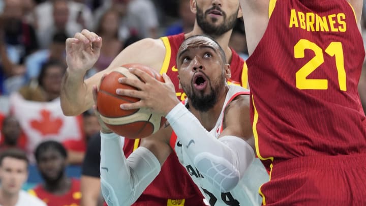 Aug 2, 2024; Villeneuve-d'Ascq, France; Canada small forward Dillon Brooks (24) controls the ball against Spain small forward Santi Aldama (7) and small forward Alex Abrines (21) in the second half in a men’s group A basketball game during the Paris 2024 Olympic Summer Games at Stade Pierre-Mauroy.